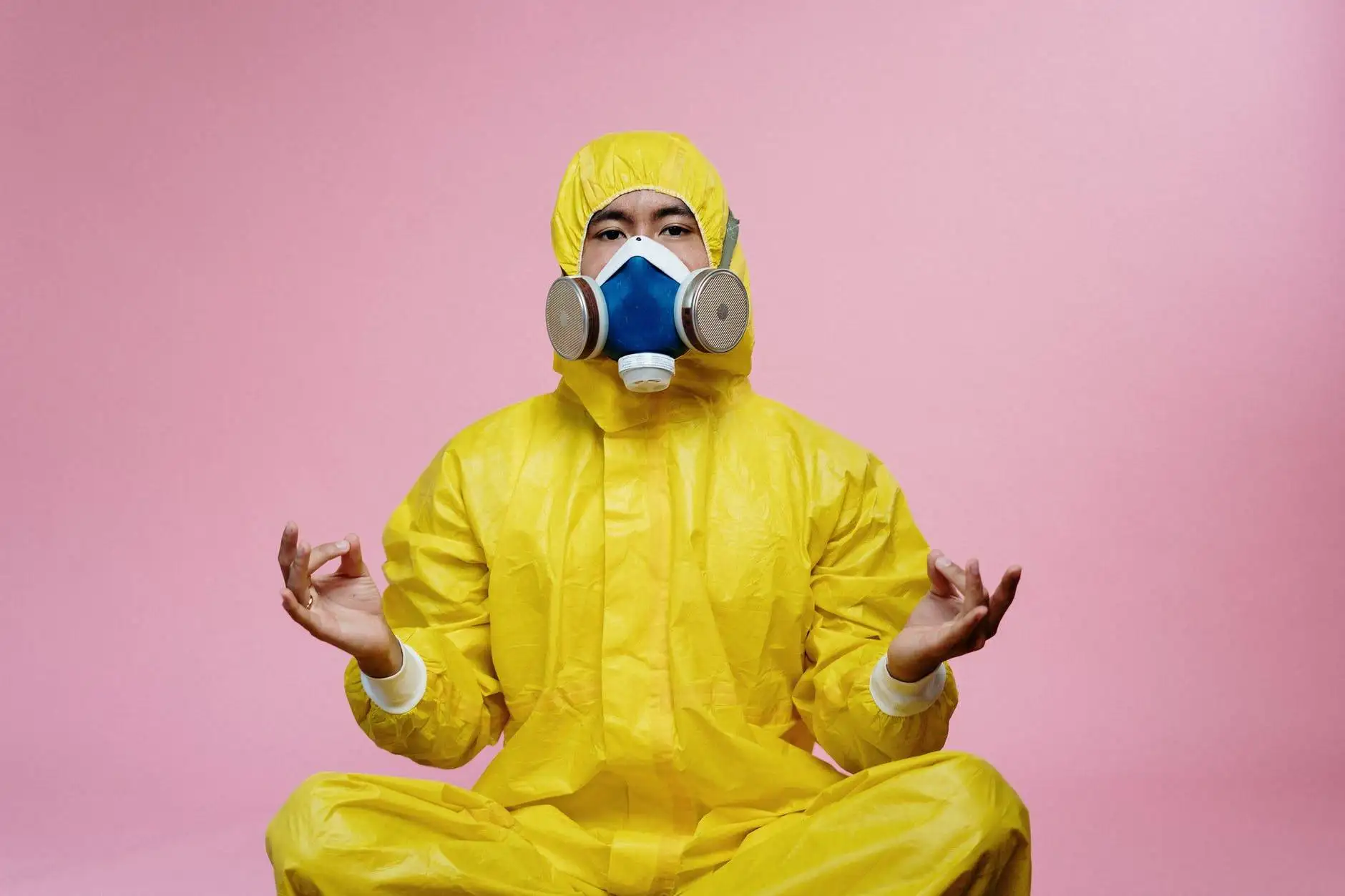 person in yellow protective suit doing a yoga pose
