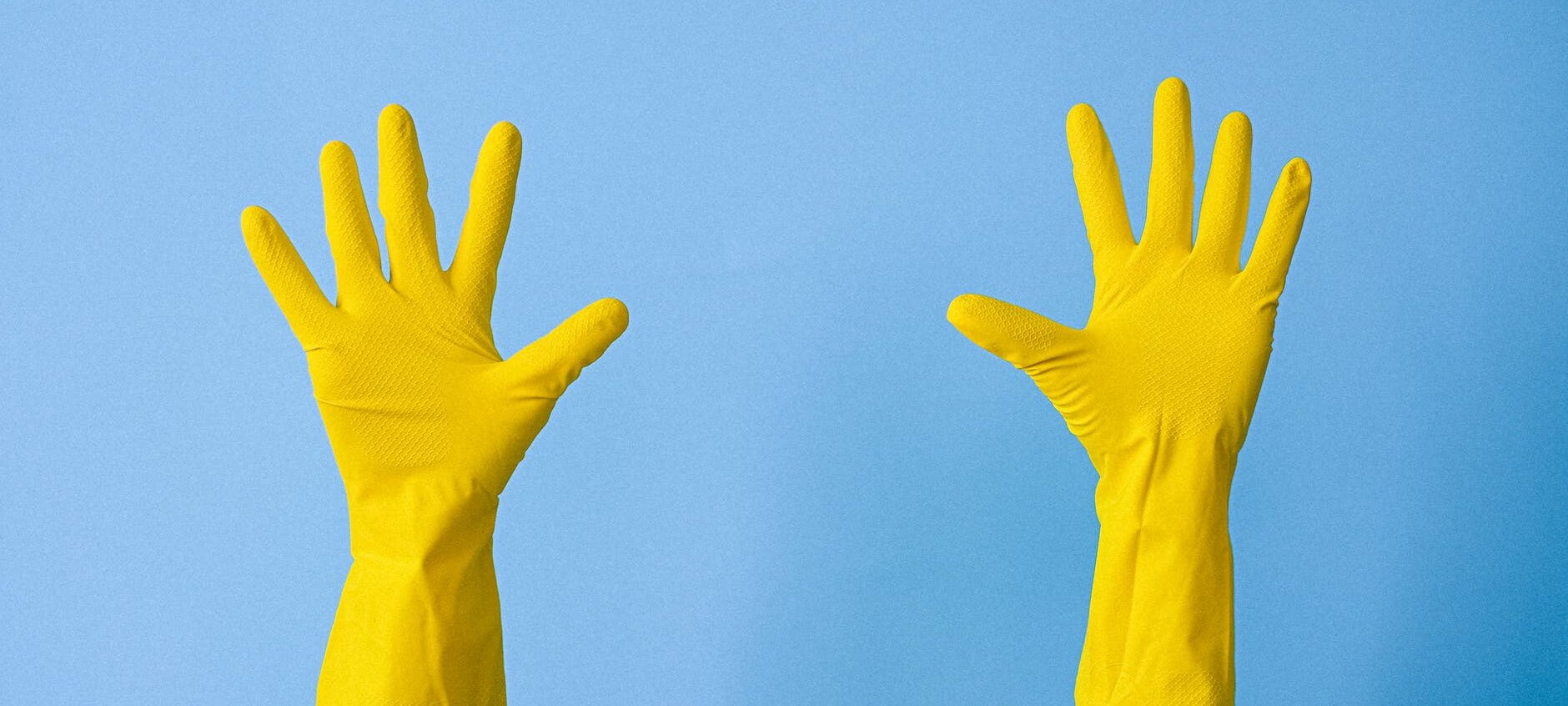 crop unrecognizable person in rubber gloves raising arms
