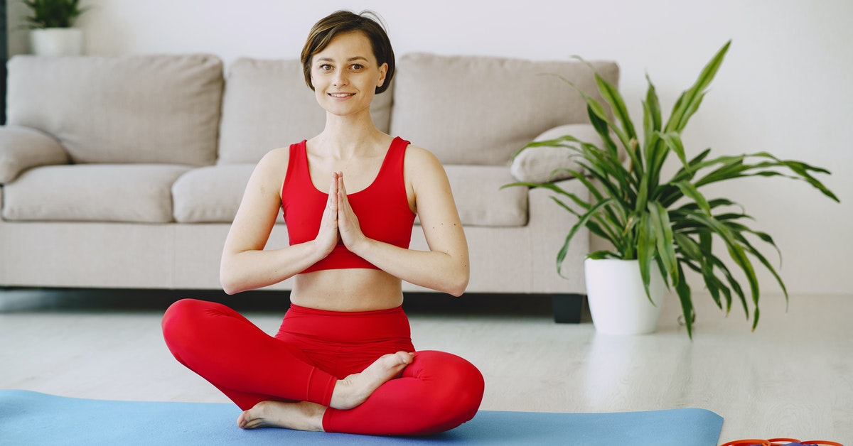Smiling woman meditating on fitness mat