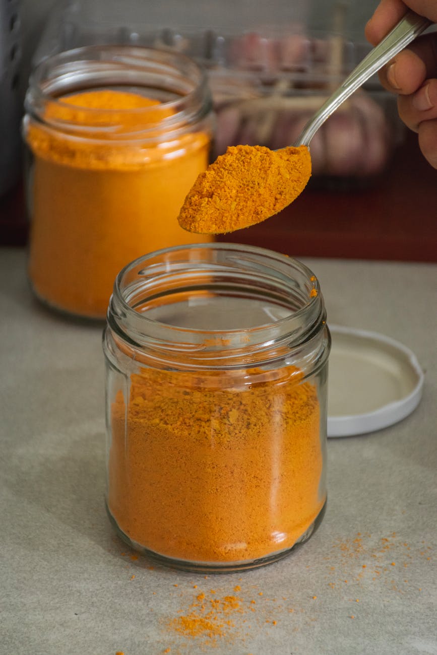 a person is using a spoon to scoop out some orange powder